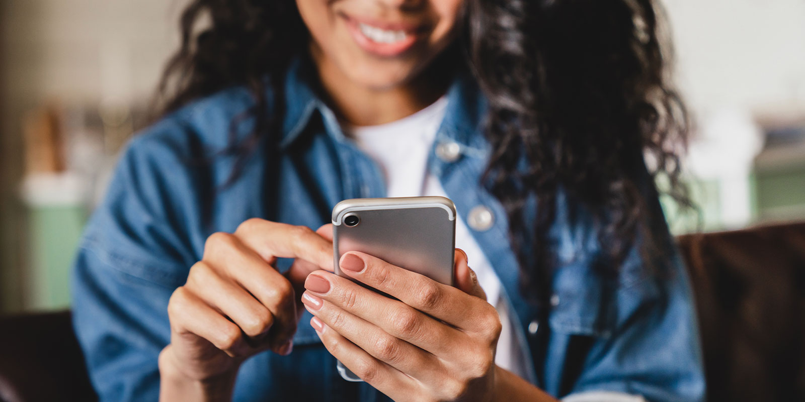 Woman holding phone while smiling