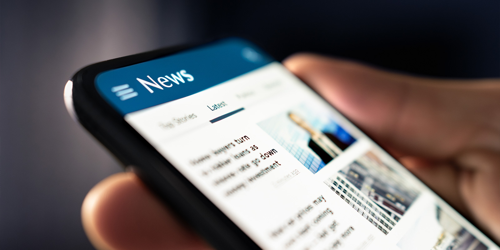 Hand holding phone reading the news